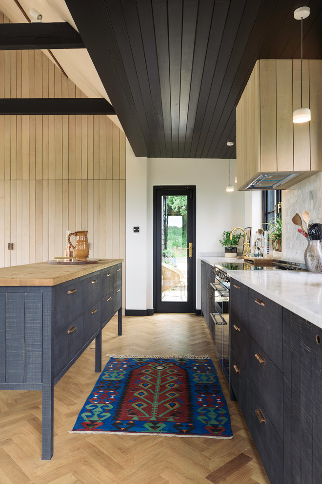 Foto på ett stort funkis linjärt kök med öppen planlösning, med en integrerad diskho, släta luckor, blå skåp, marmorbänkskiva, vitt stänkskydd, stänkskydd i tunnelbanekakel, rostfria vitvaror, mellanmörkt trägolv, en köksö och brunt golv