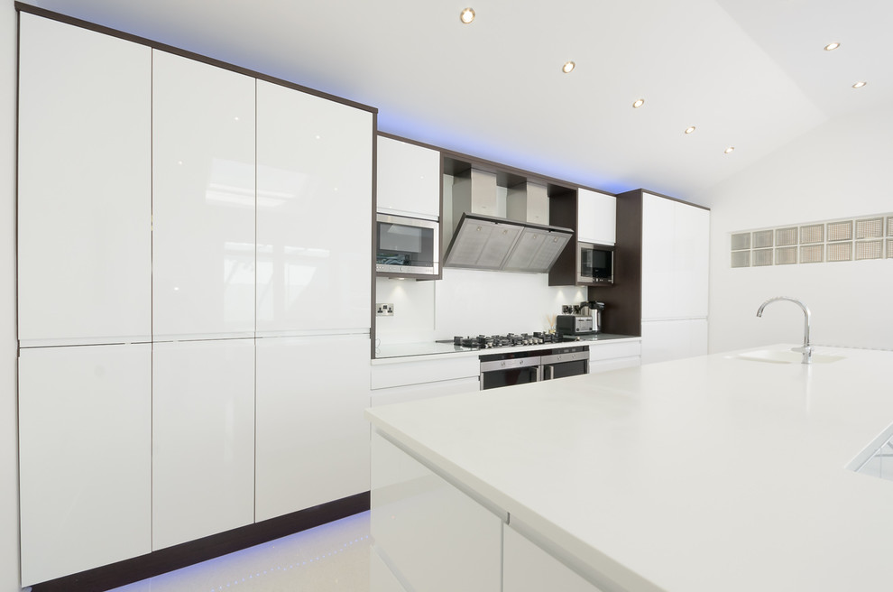 Esempio di una grande cucina design con lavello integrato, ante bianche, top in superficie solida, paraspruzzi bianco e elettrodomestici da incasso