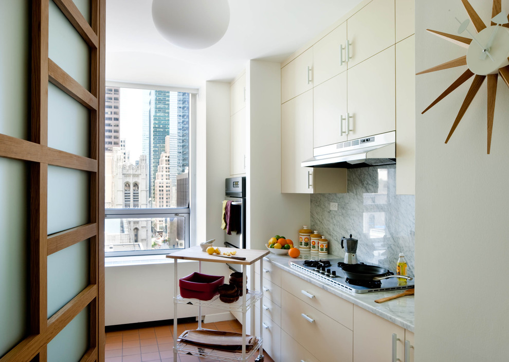 Example of a mid-century modern enclosed kitchen design in New York with marble countertops, flat-panel cabinets, white cabinets, white backsplash and stone slab backsplash