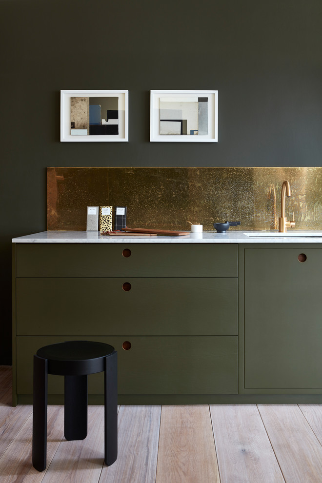 This is an example of a medium sized contemporary single-wall open plan kitchen in Other with a submerged sink, flat-panel cabinets, green cabinets, marble worktops, metallic splashback, light hardwood flooring and no island.