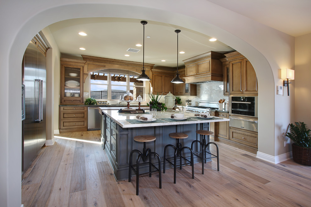 Photo of a large contemporary l-shaped open plan kitchen in Orange County with stainless steel appliances and an island.