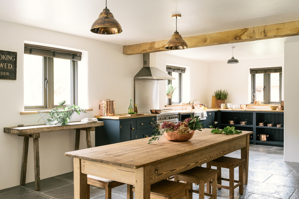 This is an example of a large rustic l-shaped kitchen/diner in Other with open cabinets, blue cabinets, wood worktops, limestone flooring and no island.