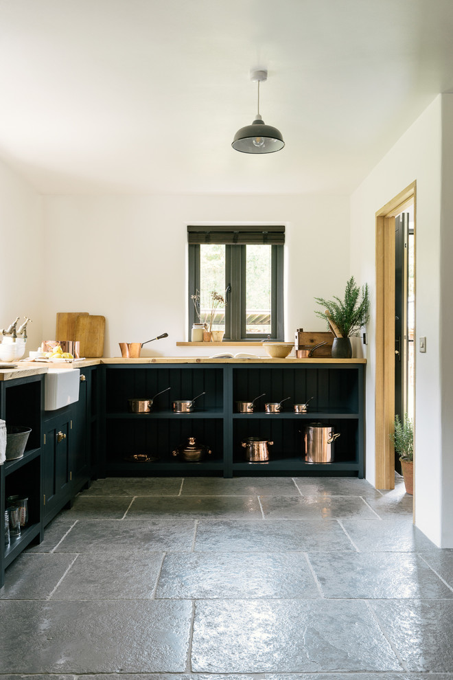 Inspiration for a medium sized rural l-shaped kitchen/diner in Other with a belfast sink, shaker cabinets, blue cabinets, wood worktops, stainless steel appliances, limestone flooring and no island.