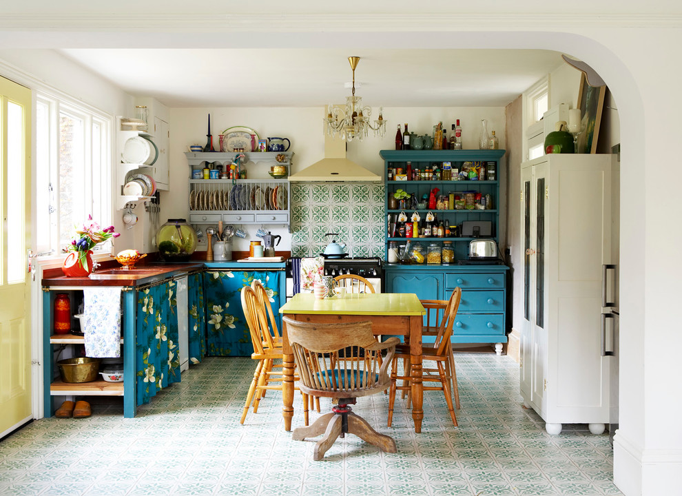 Inspiration pour une cuisine américaine bohème en L avec des portes de placard bleues et une crédence verte.