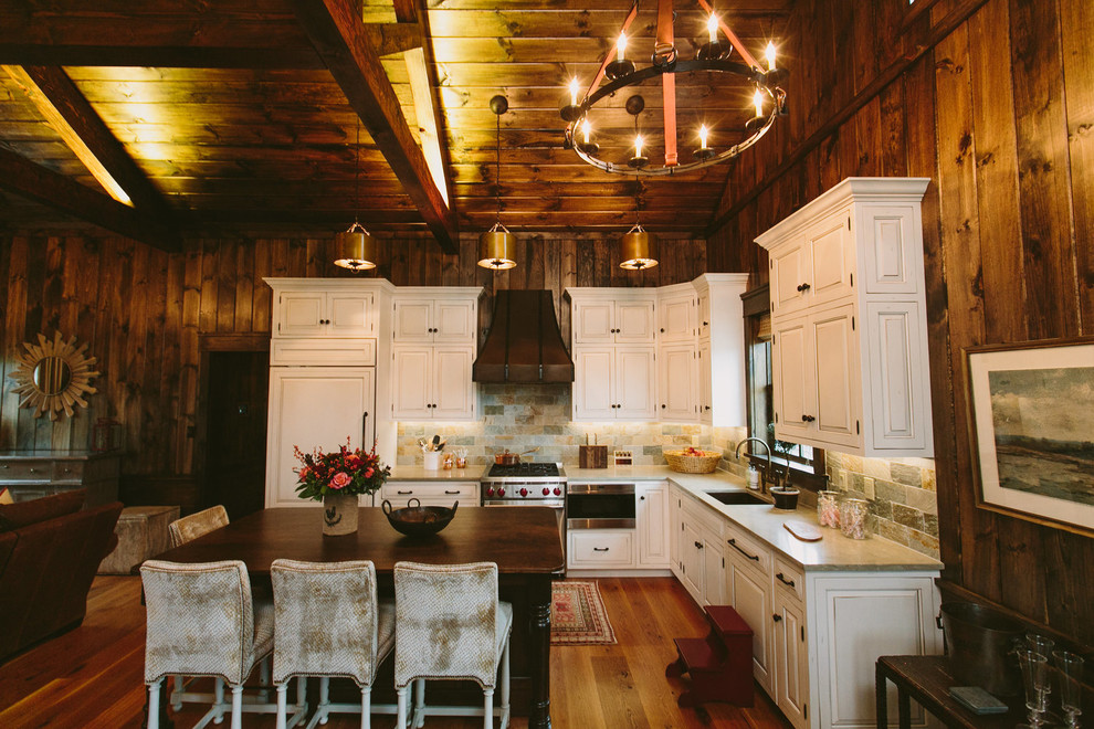 Eat-in kitchen - large rustic l-shaped medium tone wood floor eat-in kitchen idea in Baltimore with an undermount sink, raised-panel cabinets, white cabinets, limestone countertops, multicolored backsplash, stone tile backsplash, stainless steel appliances and no island