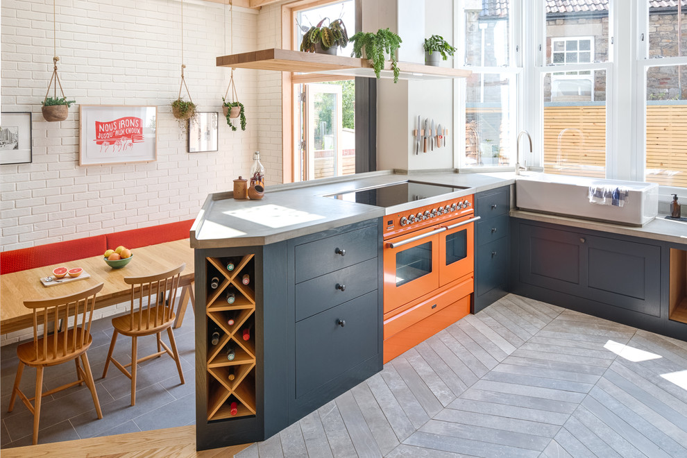 Foto på ett vintage grå kök och matrum, med svarta skåp, bänkskiva i betong, färgglada vitvaror, en halv köksö och grått golv