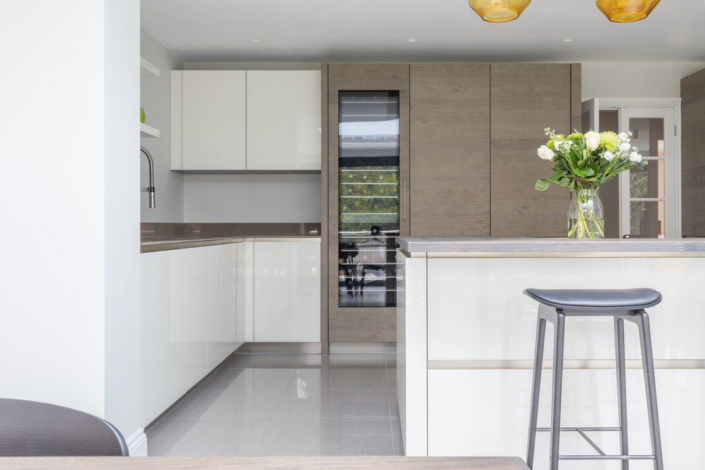 Inspiration for a large contemporary galley open plan kitchen in Sussex with flat-panel cabinets and an island.
