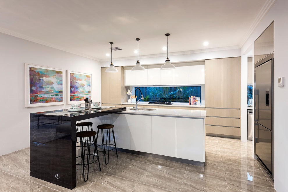 This is an example of a medium sized modern galley open plan kitchen in Perth with a double-bowl sink, flat-panel cabinets, beige cabinets, engineered stone countertops, glass sheet splashback, stainless steel appliances, porcelain flooring and an island.