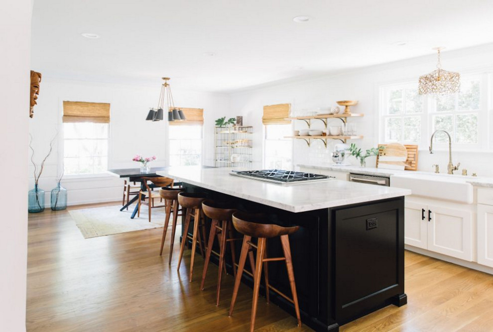 Inspiration for a mid-sized transitional single-wall light wood floor eat-in kitchen remodel in San Francisco with a farmhouse sink, shaker cabinets, white cabinets, quartzite countertops, white backsplash, stainless steel appliances and an island