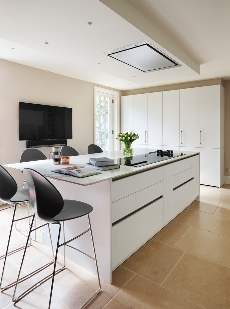 Immagine di un cucina con isola centrale minimal con ante lisce, pavimento beige e top bianco