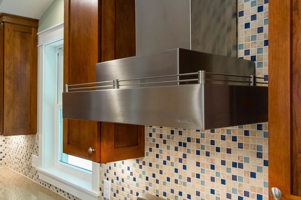 Example of a large cottage l-shaped light wood floor open concept kitchen design in Minneapolis with an undermount sink, shaker cabinets, medium tone wood cabinets, quartz countertops, blue backsplash, glass tile backsplash, stainless steel appliances and an island