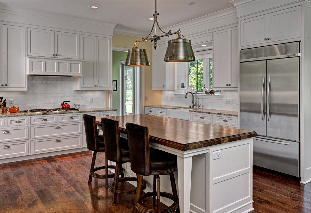 Inspiration for a timeless l-shaped eat-in kitchen remodel in Minneapolis with a farmhouse sink, shaker cabinets, white cabinets, granite countertops, white backsplash, subway tile backsplash and stainless steel appliances