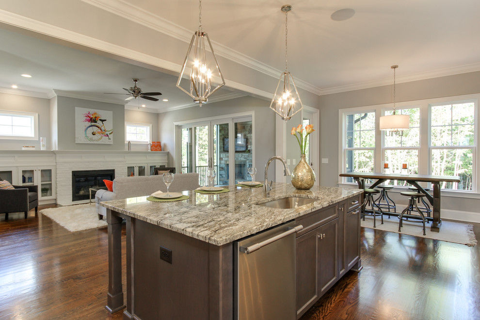 Mittelgroße Klassische Küche mit Waschbecken, hellbraunen Holzschränken, Granit-Arbeitsplatte, braunem Holzboden, Kücheninsel und braunem Boden in Raleigh