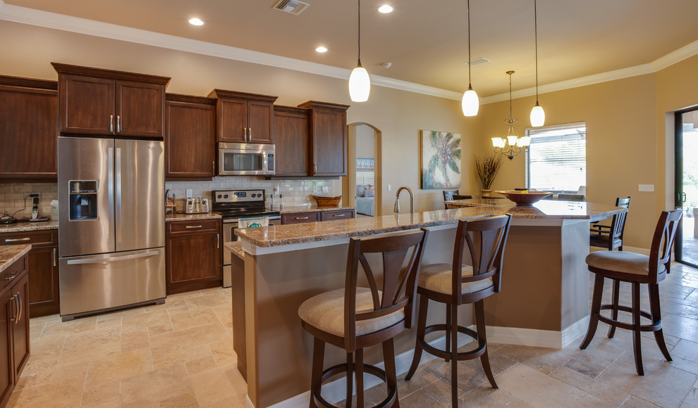 Large tuscan galley travertine floor open concept kitchen photo in Miami with shaker cabinets, medium tone wood cabinets, granite countertops, beige backsplash, stone tile backsplash, an island, an undermount sink and stainless steel appliances