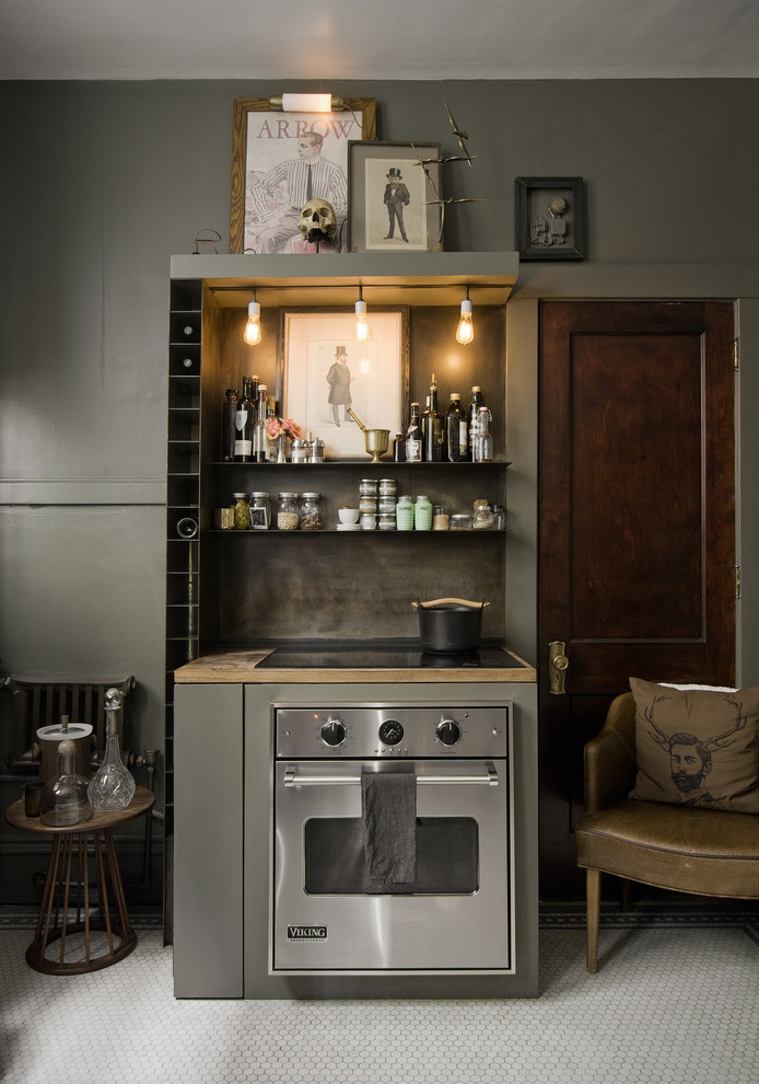 Imagen de cocina bohemia con armarios tipo vitrina, puertas de armario grises, encimera de madera, electrodomésticos de acero inoxidable y suelo de baldosas de cerámica