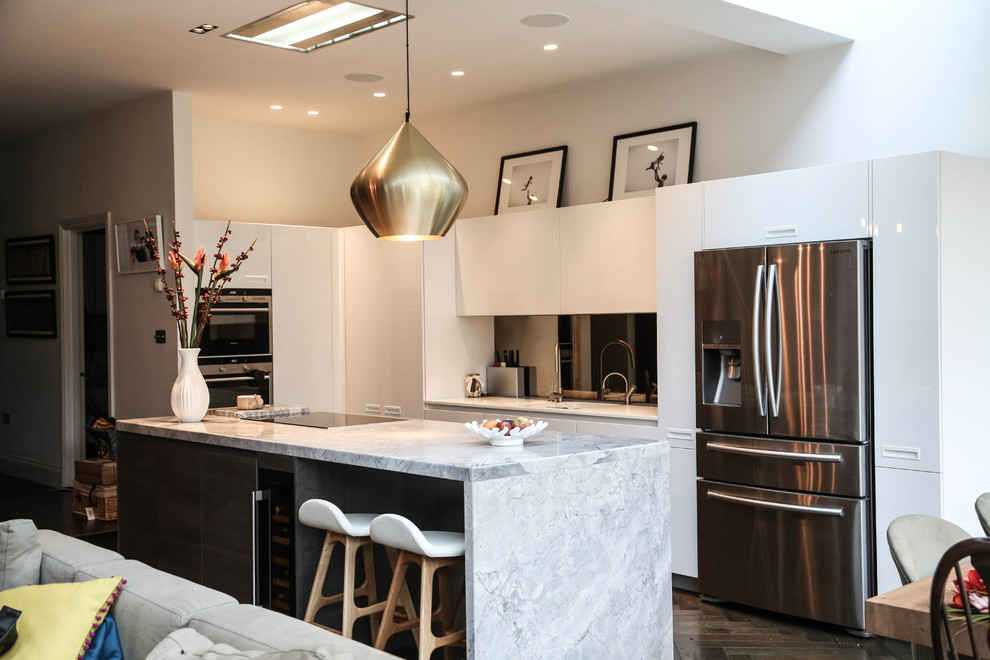 Inspiration for a large contemporary open plan kitchen in London with white cabinets, marble worktops, brown splashback, mirror splashback, stainless steel appliances, dark hardwood flooring and an island.