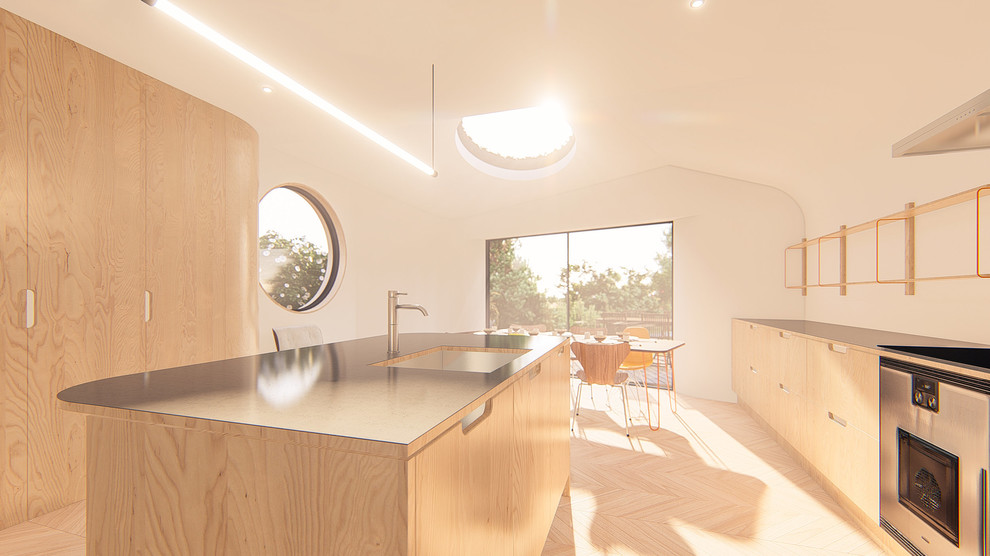 Foto på ett mellanstort funkis kök, med en integrerad diskho, släta luckor, skåp i ljust trä, bänkskiva i zink, rostfria vitvaror, ljust trägolv, en köksö och brunt golv