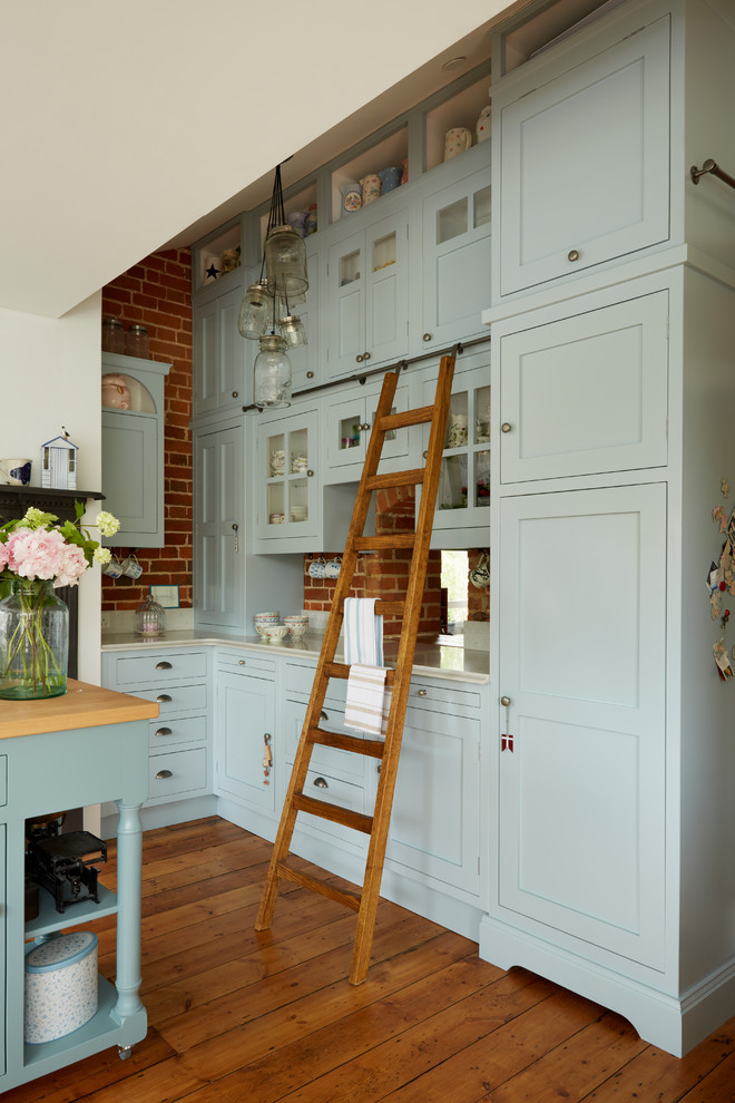 Imagen de cocina clásica grande con armarios estilo shaker, puertas de armario azules, encimera de cuarcita, suelo de madera en tonos medios y una isla