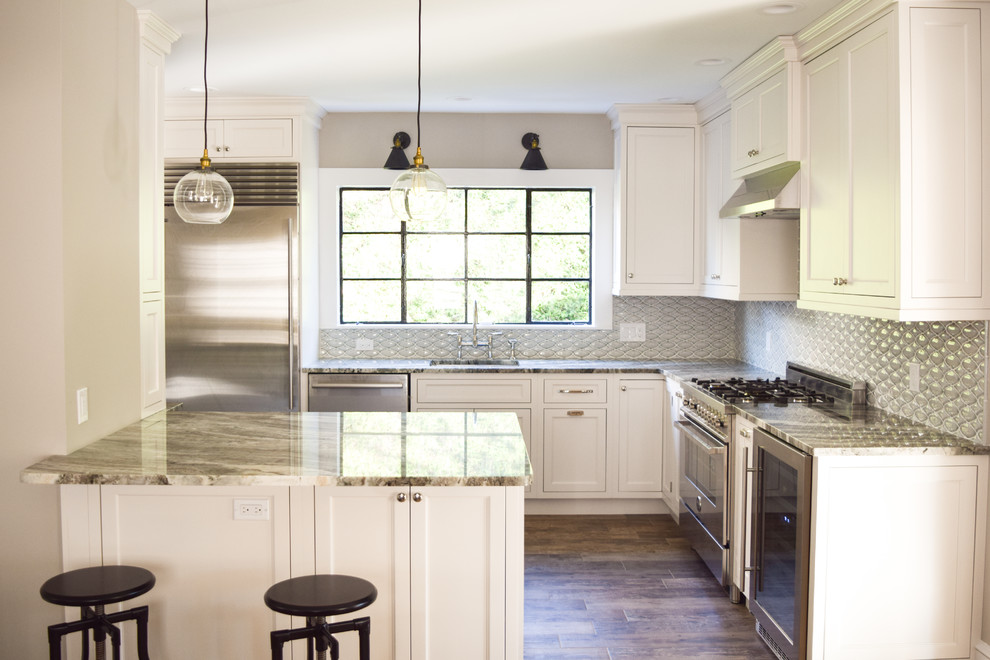 Small cottage l-shaped porcelain tile eat-in kitchen photo in New York with an undermount sink, shaker cabinets, white cabinets, quartzite countertops, blue backsplash, glass tile backsplash, stainless steel appliances and a peninsula