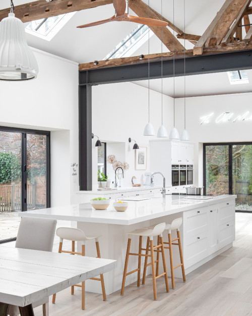 Open Concept White Kitchen Cabinets with White Central Island and Light Wood Floor