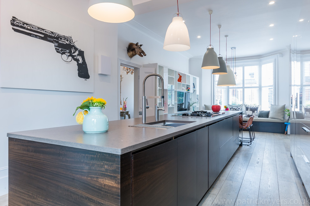 Foto di una grande cucina contemporanea con lavello sottopiano, ante lisce, ante bianche, elettrodomestici da incasso e pavimento marrone
