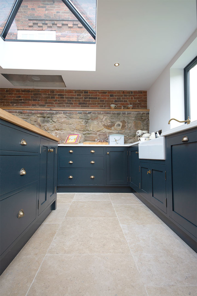 Ispirazione per un cucina con isola centrale country di medie dimensioni con ante in stile shaker, ante blu, pavimento in pietra calcarea e pavimento beige