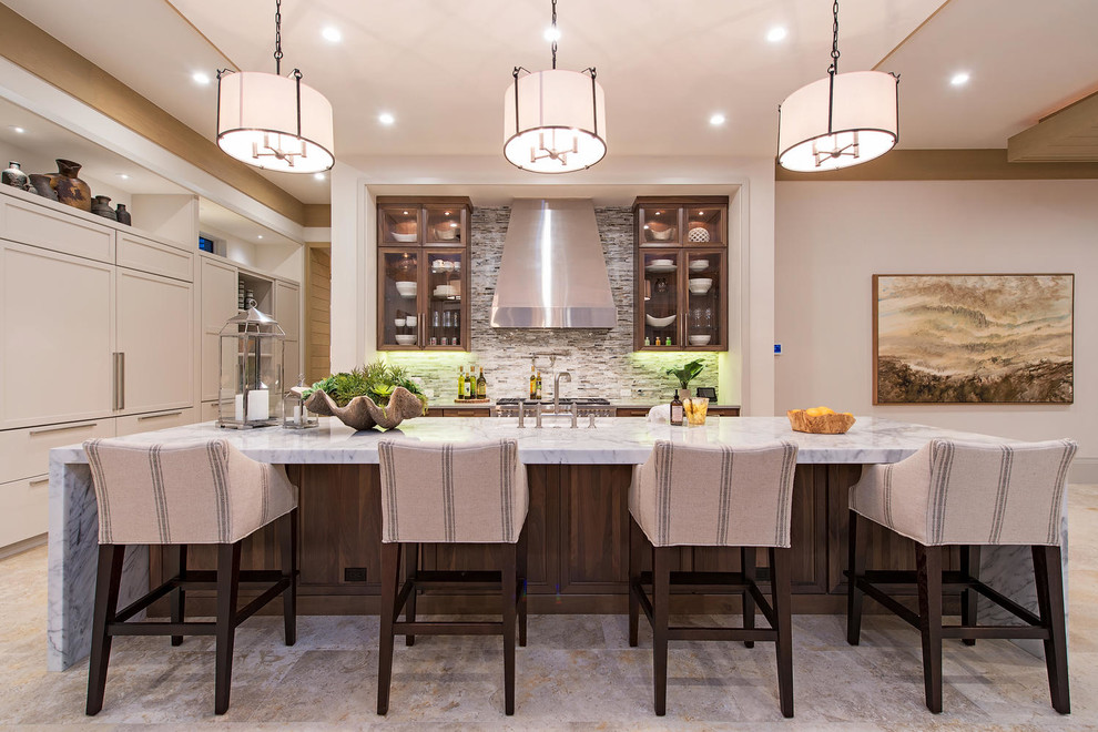 Inredning av ett klassiskt mycket stort linjärt kök med öppen planlösning, med en undermonterad diskho, skåp i shakerstil, grå skåp, marmorbänkskiva, flerfärgad stänkskydd, stänkskydd i stenkakel, rostfria vitvaror, travertin golv och en köksö