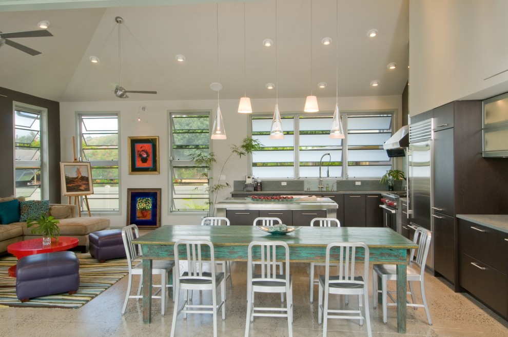 Imagen de cocinas en L tropical abierta con electrodomésticos de acero inoxidable, armarios con paneles lisos y puertas de armario de madera en tonos medios