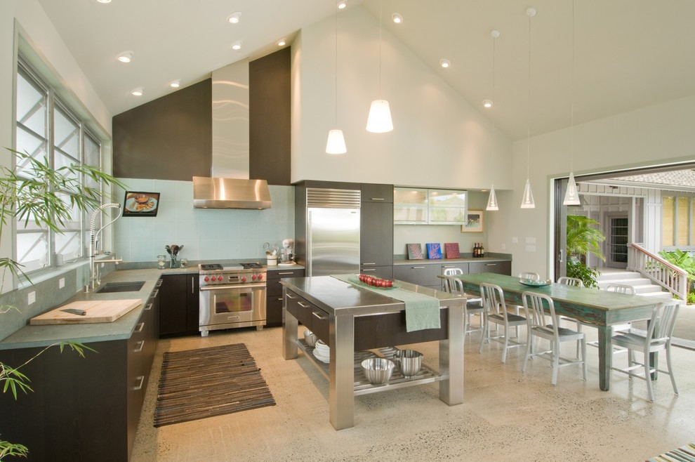 Offene Küche in L-Form mit flächenbündigen Schrankfronten, Küchengeräten aus Edelstahl, Edelstahl-Arbeitsplatte, dunklen Holzschränken, Küchenrückwand in Blau und grüner Arbeitsplatte in Hawaii