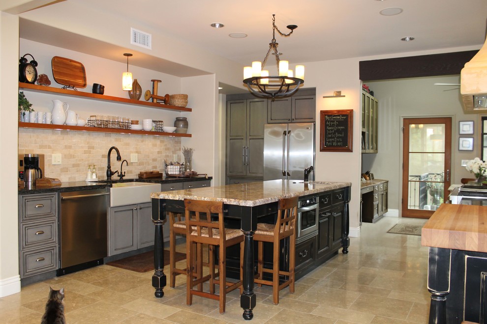 Exempel på ett stort rustikt kök, med en rustik diskho, luckor med infälld panel, granitbänkskiva, beige stänkskydd, stänkskydd i cementkakel, rostfria vitvaror, travertin golv, en köksö och gröna skåp