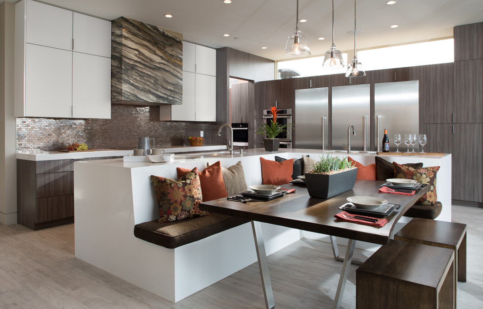 Cette image montre une cuisine américaine bicolore design en L avec un placard à porte plane, des portes de placard grises, une crédence métallisée, une crédence en mosaïque, un électroménager en acier inoxydable et îlot.