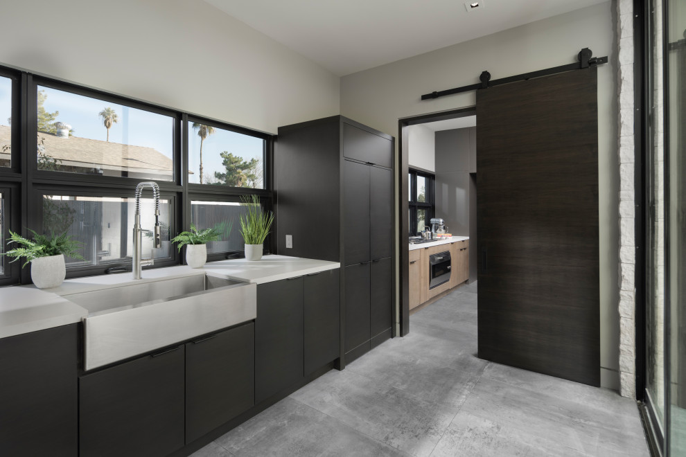 Large trendy porcelain tile and gray floor enclosed kitchen photo in Las Vegas with a farmhouse sink, flat-panel cabinets, dark wood cabinets, quartz countertops, white countertops, window backsplash, paneled appliances and no island