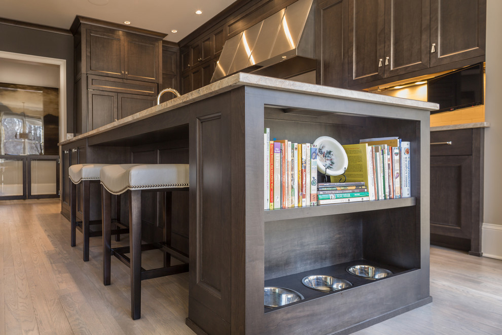 Large transitional u-shaped light wood floor open concept kitchen photo in Atlanta with a double-bowl sink, recessed-panel cabinets, dark wood cabinets, granite countertops, paneled appliances and an island