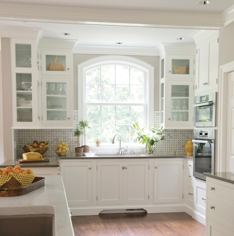 Inspiration for a timeless kitchen remodel in Philadelphia with glass-front cabinets, white cabinets, quartz countertops, stone tile backsplash and multicolored backsplash