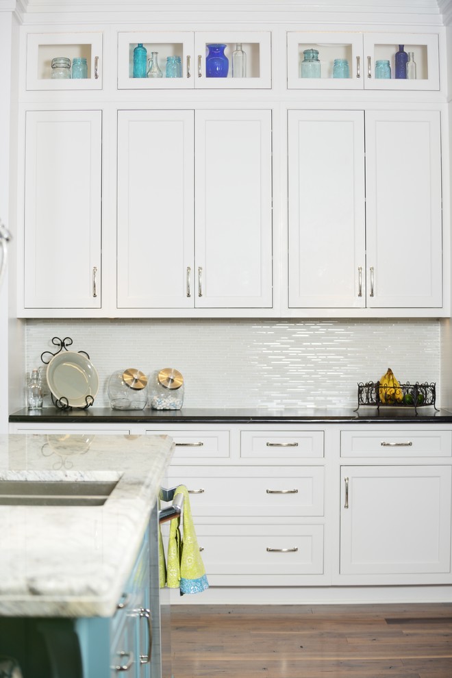 ローリーにある高級な広いトランジショナルスタイルのおしゃれなキッチン (白いキャビネット、ソープストーンカウンター、白いキッチンパネル、ガラスタイルのキッチンパネル、シルバーの調理設備、無垢フローリング、茶色い床) の写真