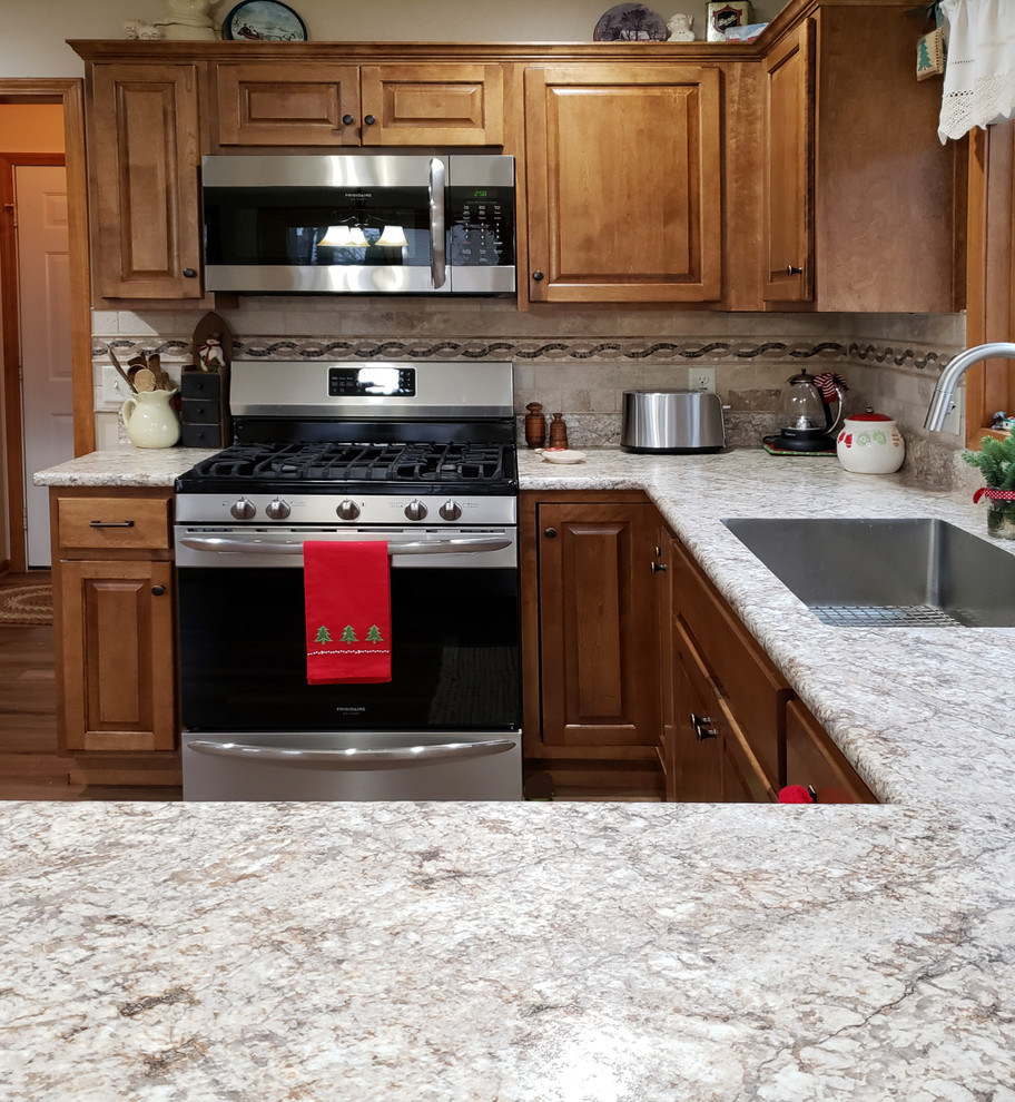 Exempel på ett mellanstort klassiskt flerfärgad flerfärgat kök, med en undermonterad diskho, luckor med upphöjd panel, laminatbänkskiva, beige stänkskydd, stänkskydd i keramik, rostfria vitvaror, vinylgolv, en halv köksö, brunt golv och skåp i mellenmörkt trä