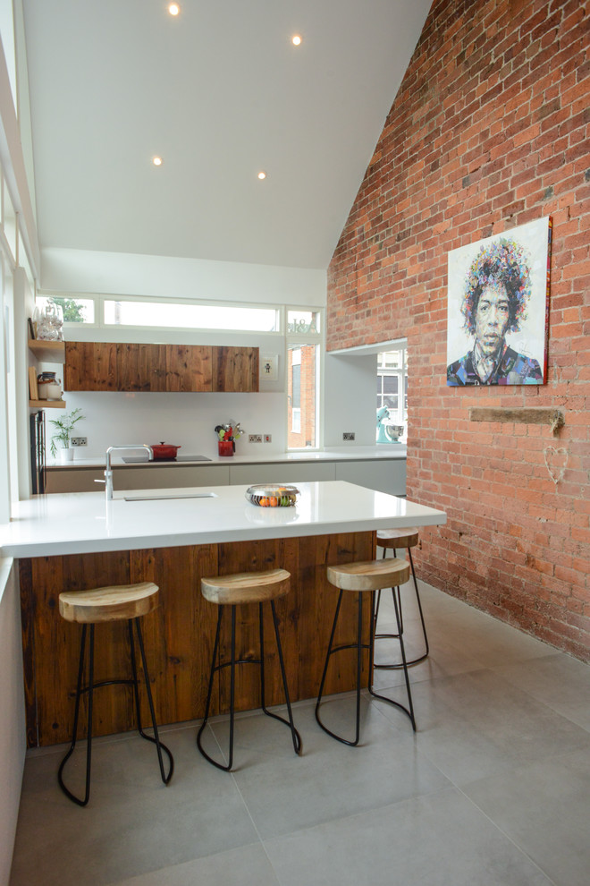 Immagine di una cucina minimal di medie dimensioni con ante lisce, ante bianche, paraspruzzi bianco, penisola e pavimento grigio