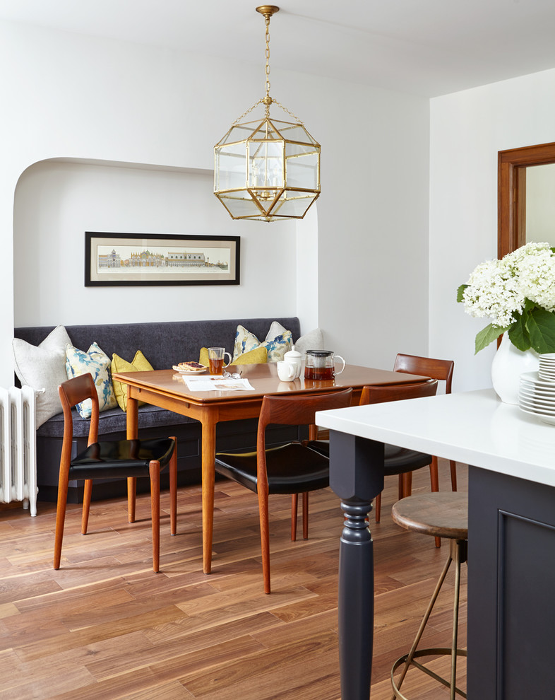 Ispirazione per una grande sala da pranzo aperta verso la cucina classica con pareti bianche, nessun camino, pavimento in legno massello medio e pavimento marrone