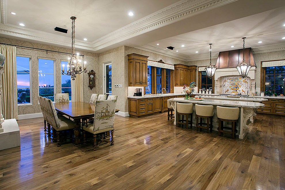 Inspiration for a huge mediterranean u-shaped medium tone wood floor eat-in kitchen remodel in Orange County with a farmhouse sink, recessed-panel cabinets, medium tone wood cabinets, limestone countertops, multicolored backsplash, cement tile backsplash, stainless steel appliances and two islands