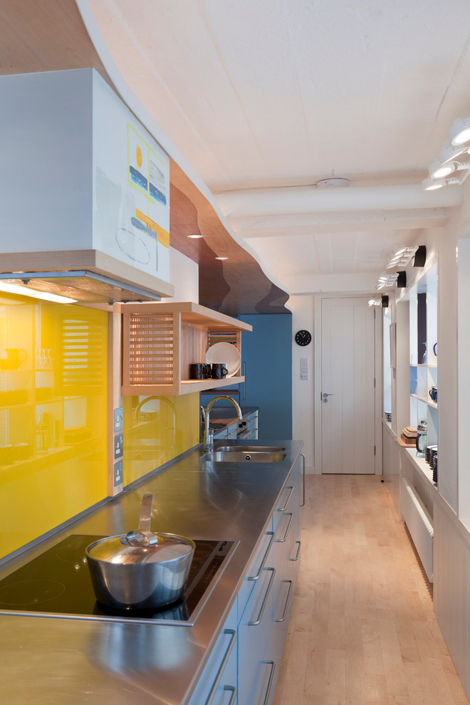 Foto de cocina nórdica con puertas de armario en acero inoxidable, encimera de acero inoxidable y electrodomésticos de acero inoxidable