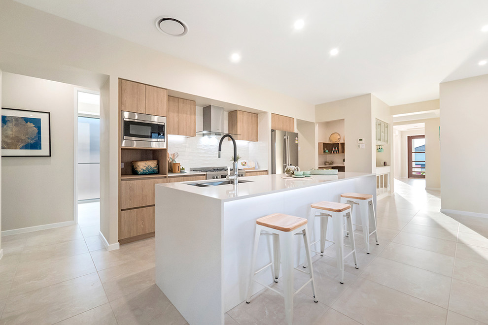 Zweizeilige Moderne Küche mit Doppelwaschbecken, Küchenrückwand in Weiß, Rückwand aus Keramikfliesen, Küchengeräten aus Edelstahl, Keramikboden, Kücheninsel, beigem Boden, flächenbündigen Schrankfronten und hellen Holzschränken in Brisbane