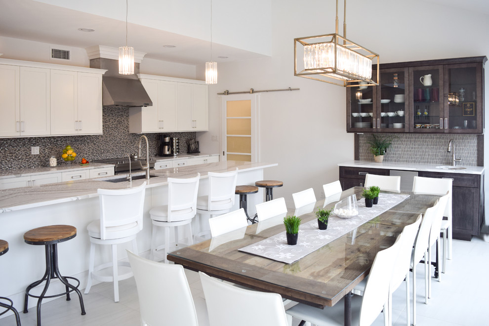 Medium sized traditional single-wall kitchen/diner in New York with a submerged sink, shaker cabinets, white cabinets, engineered stone countertops, grey splashback, glass tiled splashback, stainless steel appliances, marble flooring and an island.