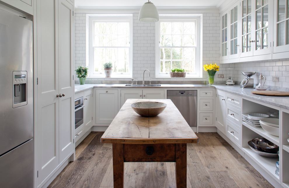 Inspiration for a timeless u-shaped enclosed kitchen remodel in Wiltshire with recessed-panel cabinets, white cabinets, marble countertops, white backsplash, subway tile backsplash and stainless steel appliances