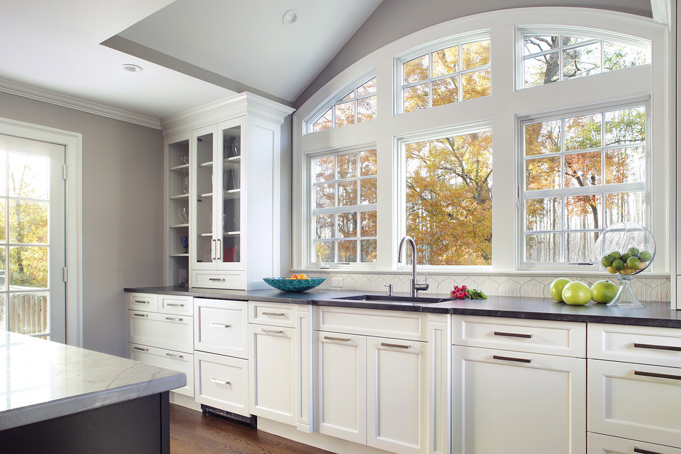 Foto de cocina clásica renovada con fregadero bajoencimera, armarios estilo shaker, puertas de armario blancas y suelo de madera oscura