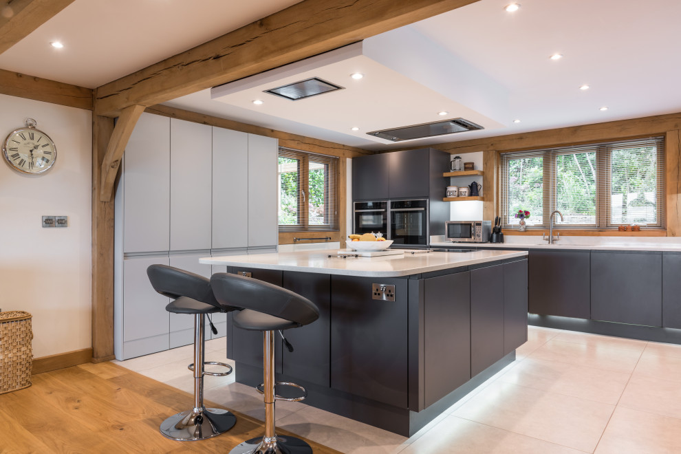 Inspiration for a rural l-shaped kitchen in Other with a submerged sink, flat-panel cabinets, grey cabinets, stainless steel appliances, an island, beige floors and white worktops.