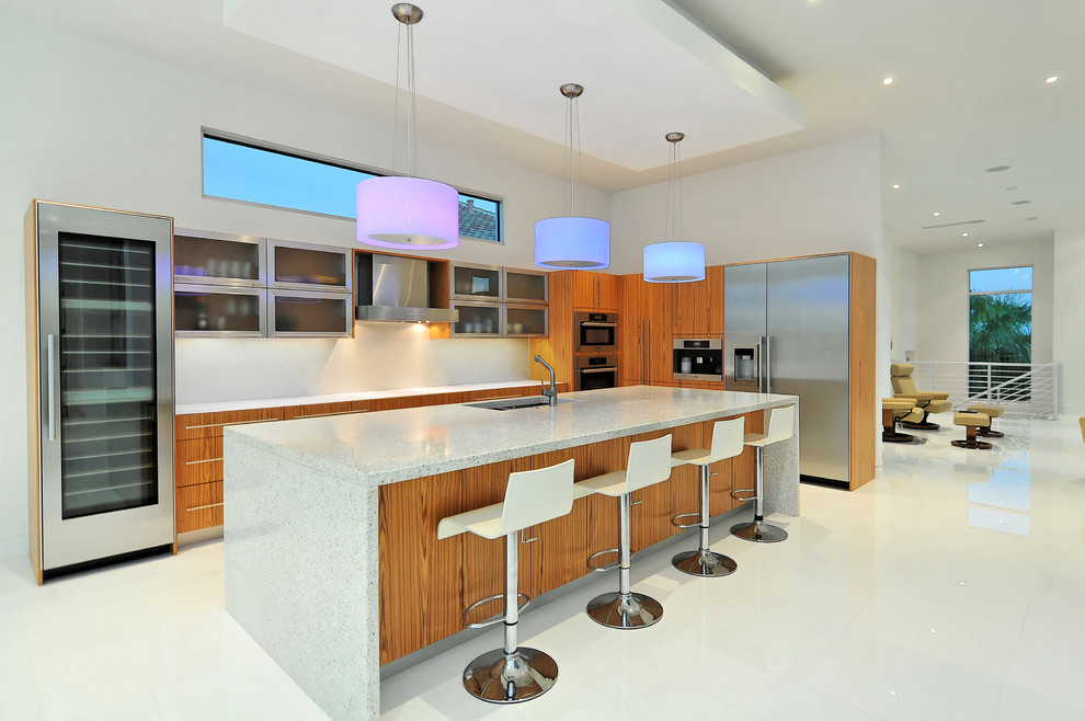 Mittelgroße Moderne Küche mit Doppelwaschbecken, Glasfronten, hellbraunen Holzschränken, Küchengeräten aus Edelstahl und Kücheninsel in Tampa