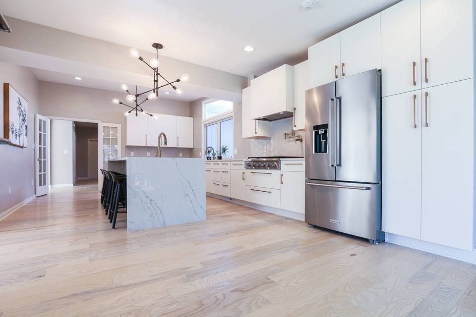 Enclosed kitchen - large contemporary l-shaped light wood floor and beige floor enclosed kitchen idea in Baltimore with an undermount sink, flat-panel cabinets, white cabinets, marble countertops, gray backsplash, ceramic backsplash, stainless steel appliances, an island and white countertops