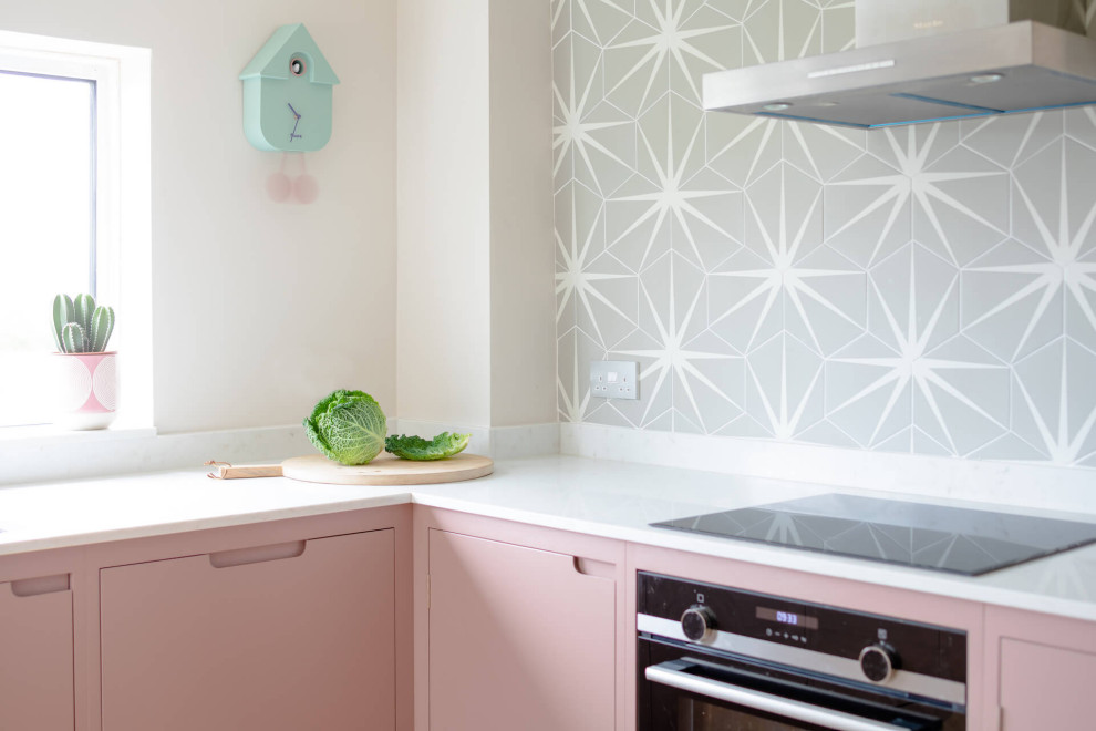 Idee per una cucina scandinava di medie dimensioni con ante lisce, ante rosa, top in quarzo composito, parquet chiaro, nessuna isola e top bianco