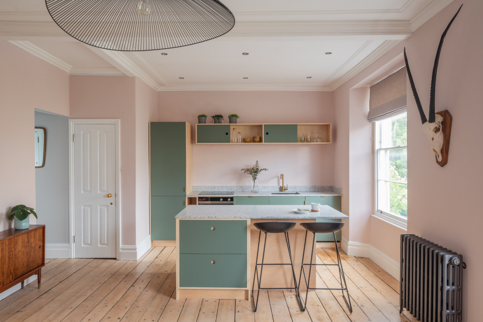 Scandi galley kitchen in Other with a submerged sink, flat-panel cabinets, green cabinets, stainless steel appliances, light hardwood flooring, beige floors and grey worktops.