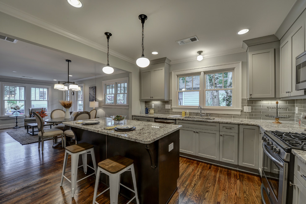 Kitchen - small traditional l-shaped medium tone wood floor kitchen idea in Atlanta with an undermount sink, shaker cabinets, gray cabinets, granite countertops, gray backsplash, ceramic backsplash, stainless steel appliances and an island